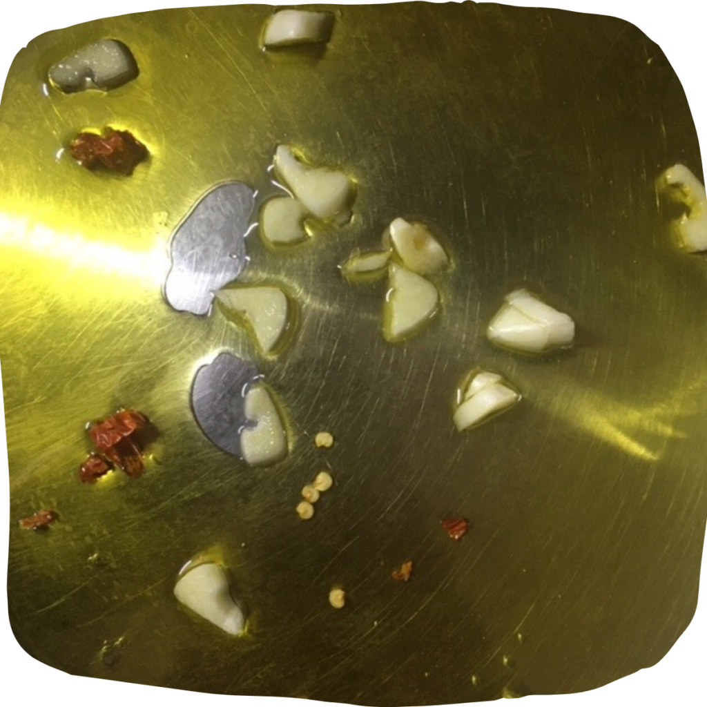 Detail na olivový olej, plátky česneku a feferonku.
