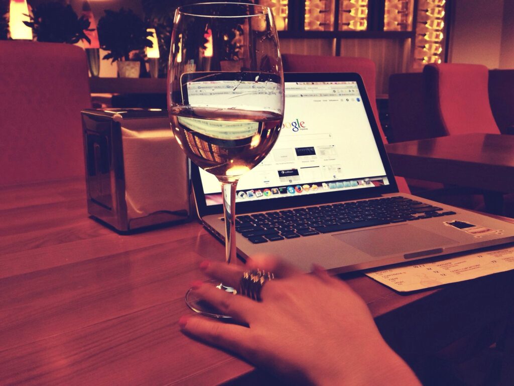 Sklenička vína v restauraci u počítače.
