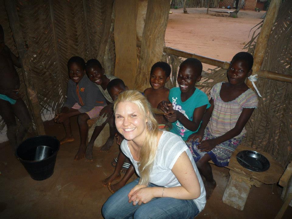 Kristýna s dětmi z místní vesnice, v chýši.