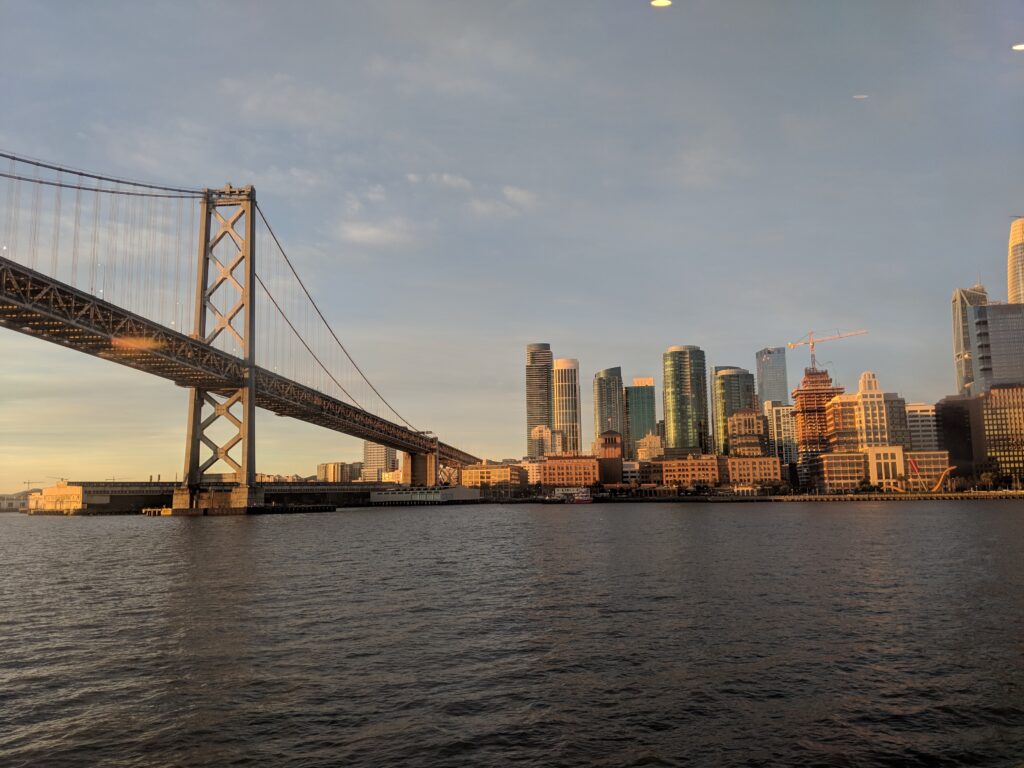Výhled přes řeku na americké velkoměsto a majestátný most.