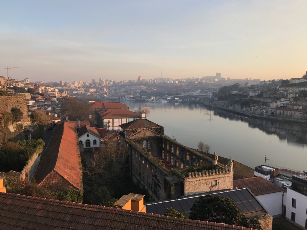 Portugalské město, v popředí historická část, vedle ní řeka a v pozadí zbytek města